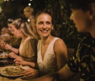 Close up shot of a young couple talking while enjoying an outdoor meal on holiday.